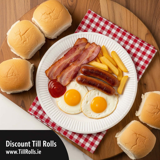 Breakfast on a 6 White Greenspirit Paper plate with eggs, bacon, sausages, and fries on a chequered tablecloth with Till Rolls branding.