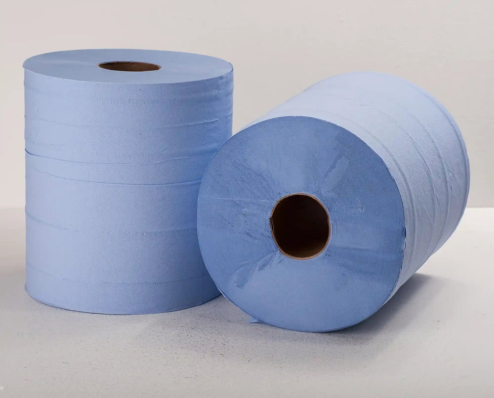Two blue paper towels rolls on a light gray background