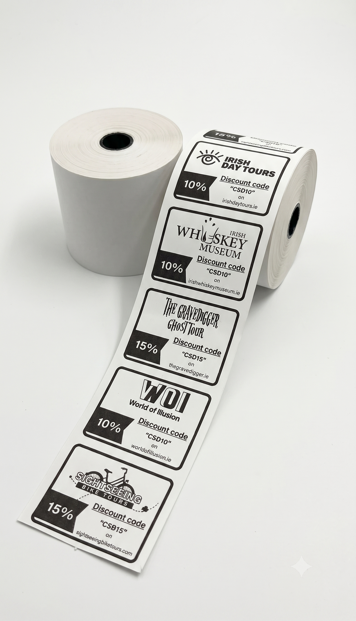 A roll of printed discount voucher with several labels unspooled, shown on a clean white background. The labels feature black and gray text and logos for attractions such as Irish Day Tours, Whiskey Museum, The Whisker Goat Track, and WDI.