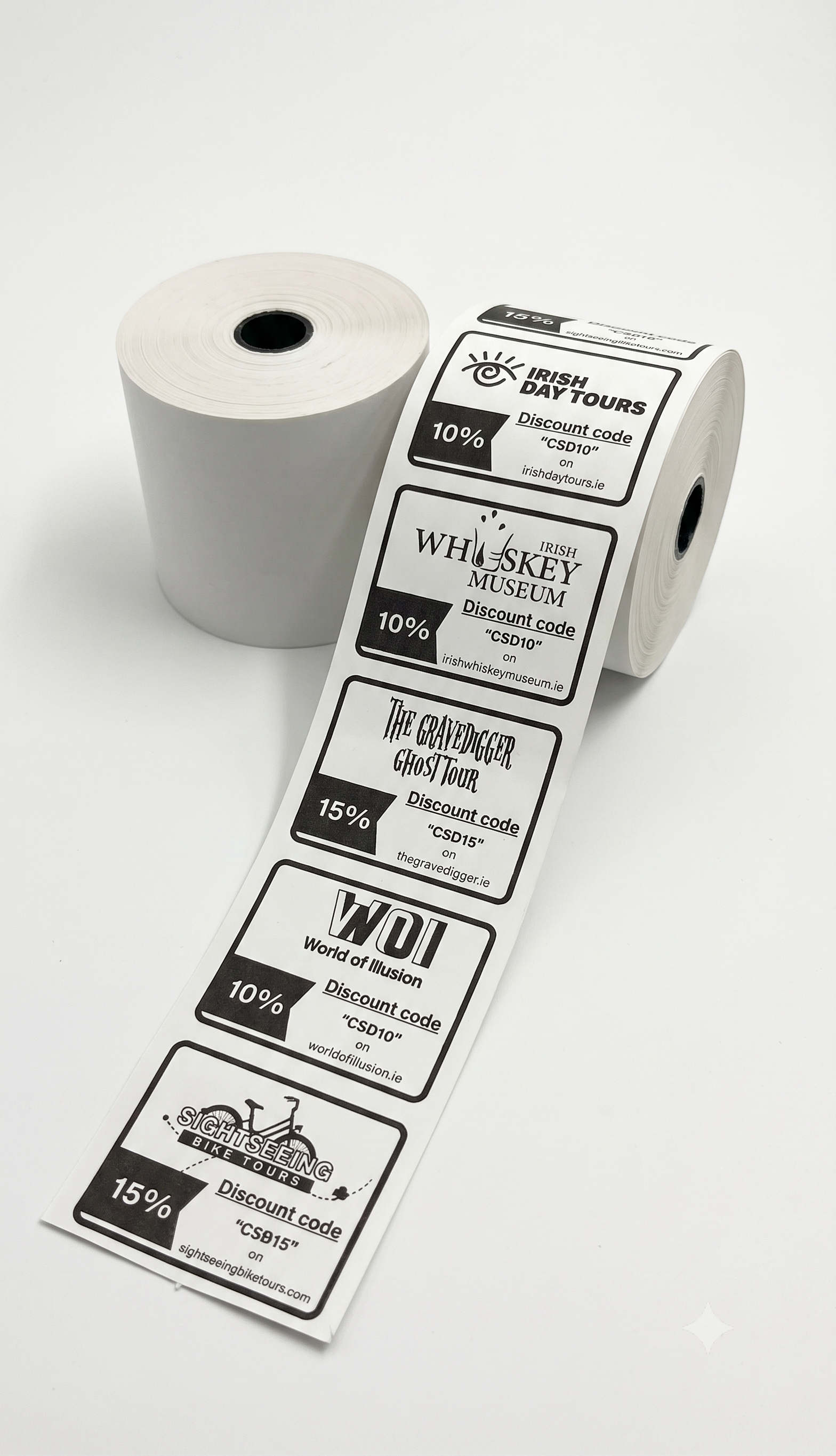 A roll of printed discount voucher with several labels unspooled, shown on a clean white background. The labels feature black and gray text and logos for attractions such as Irish Day Tours, Whiskey Museum, The Whisker Goat Track, and WDI.