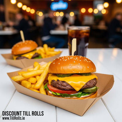 Two burgers with fries  in a 3lb Kraft Greenspirit Paper Food Tray on a table with a blurred bar background