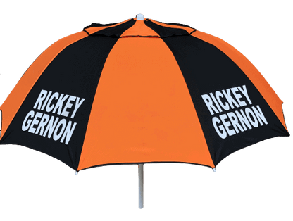 Orange and black racecourse bookmakers umbrella with 'Rickey Gernon branding on a dark background