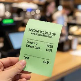 customer holding a green thermal receipts